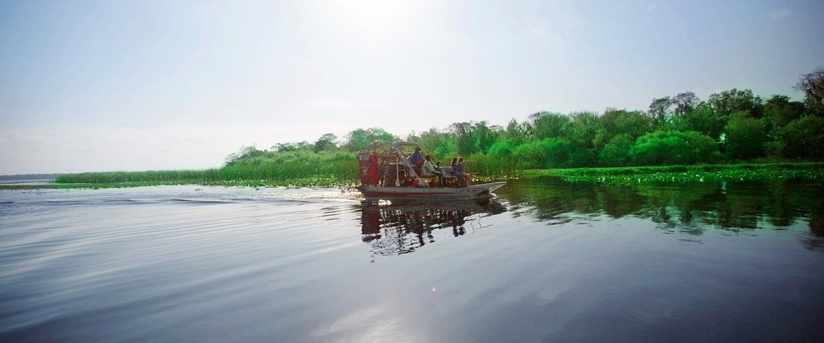 a boat traveling along a river next to a body of water